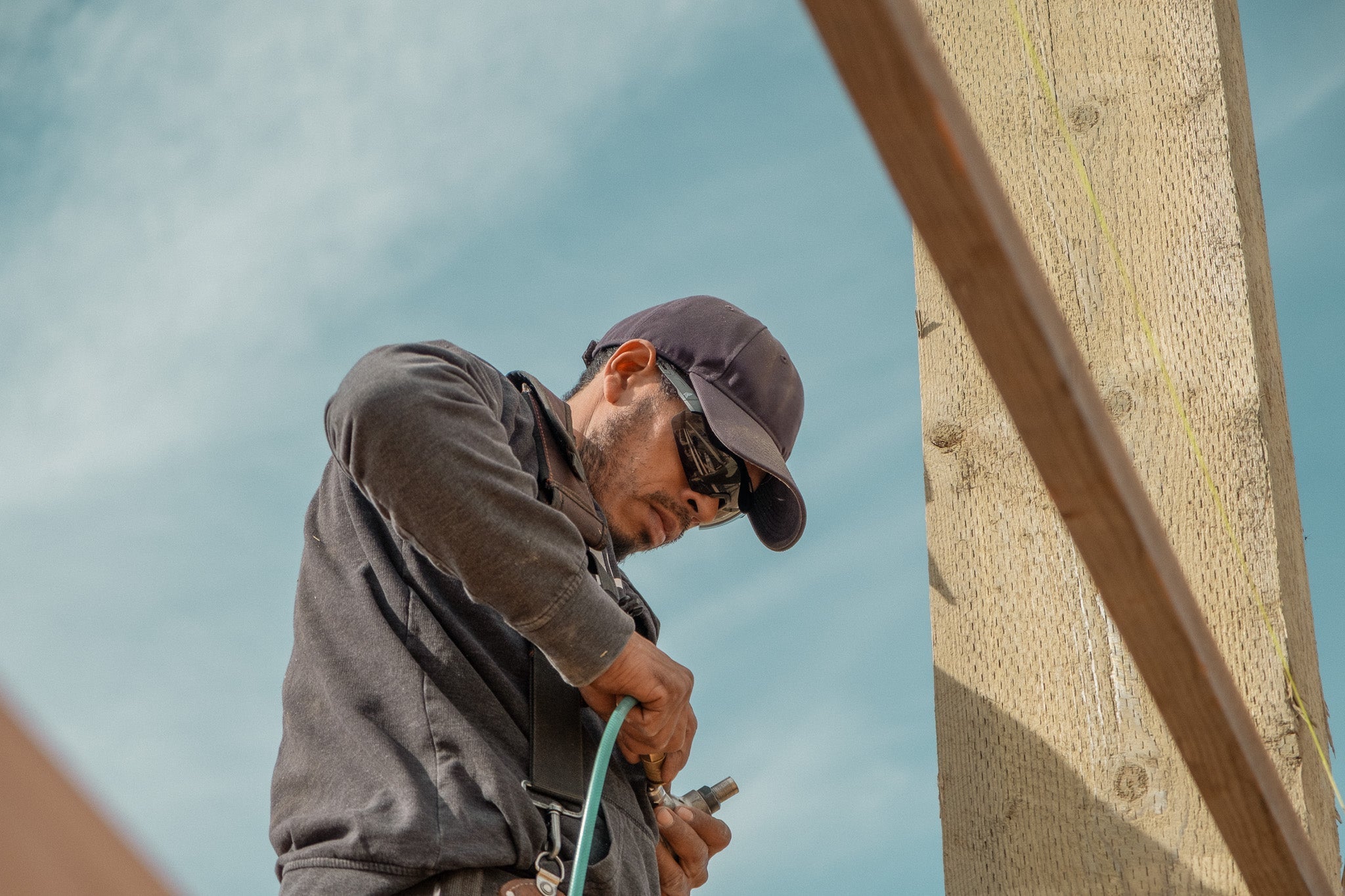 Carpenter Fixing Air Tool and Wearing Safety Glasses