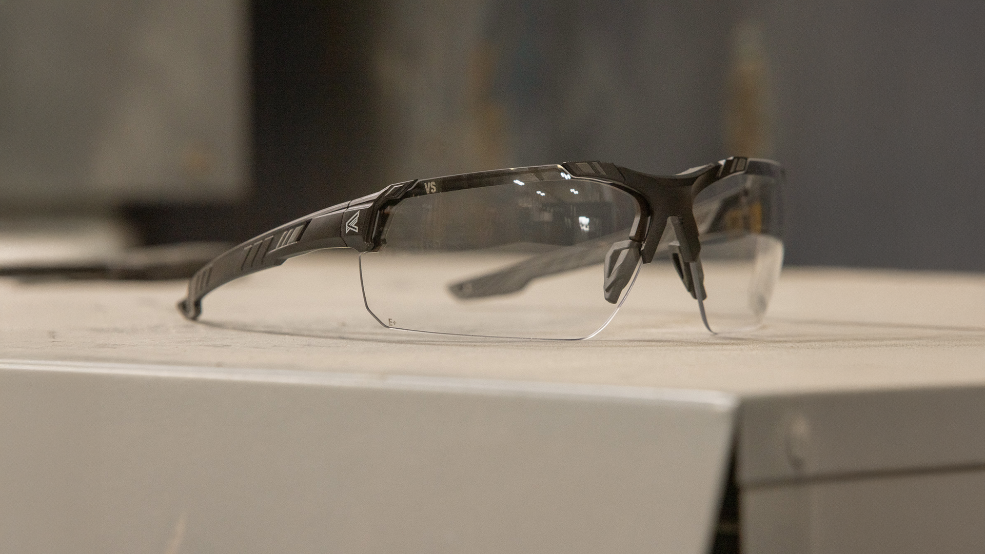 safety glasses on a metallic surface with a blurred background