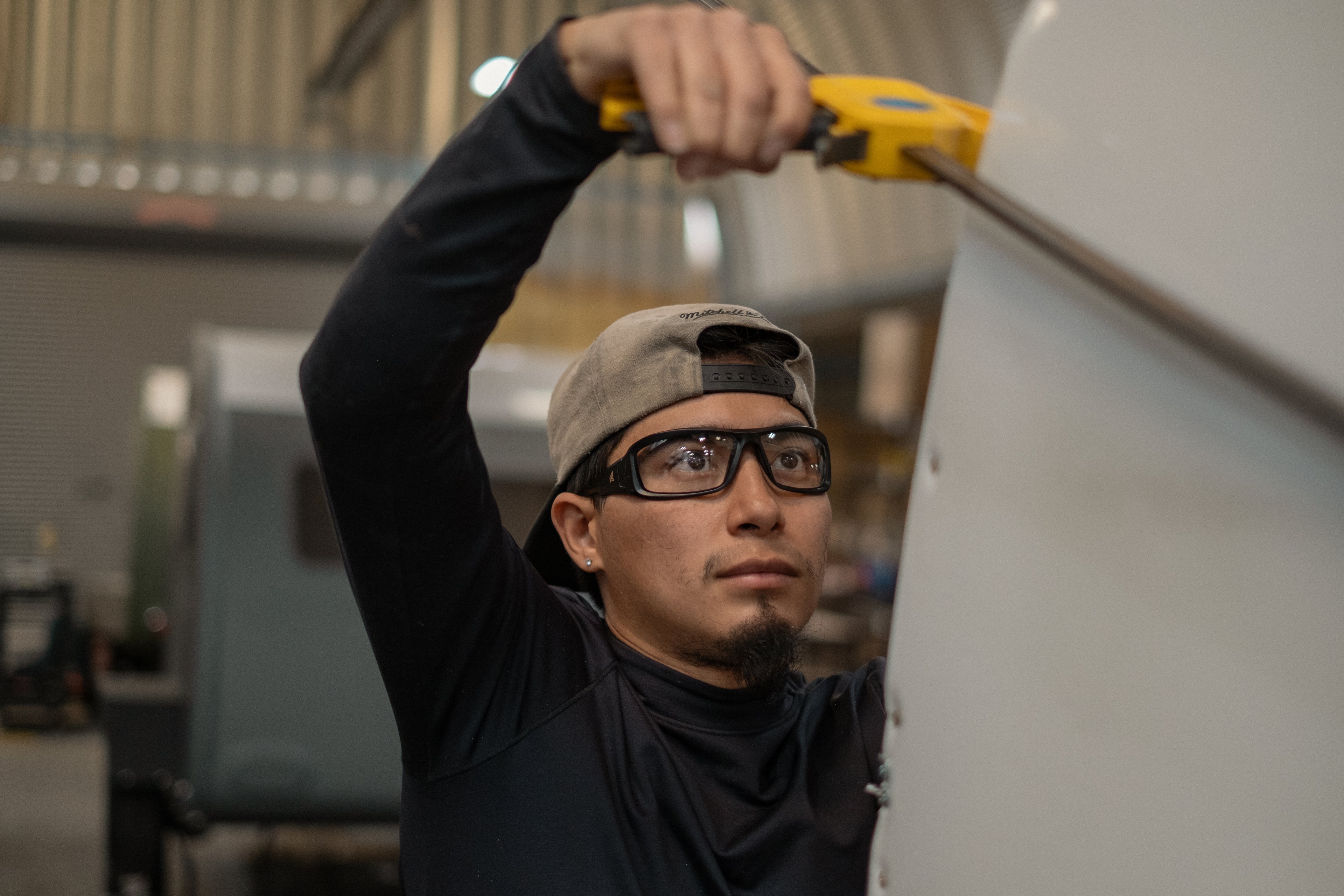 Man wearing safety glasses working on building a camping trailer teardrop style camper