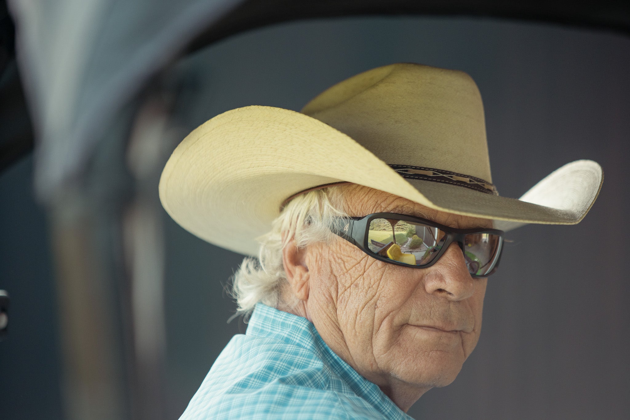 man in cowboy hat wearing silver-mirror safety glasses