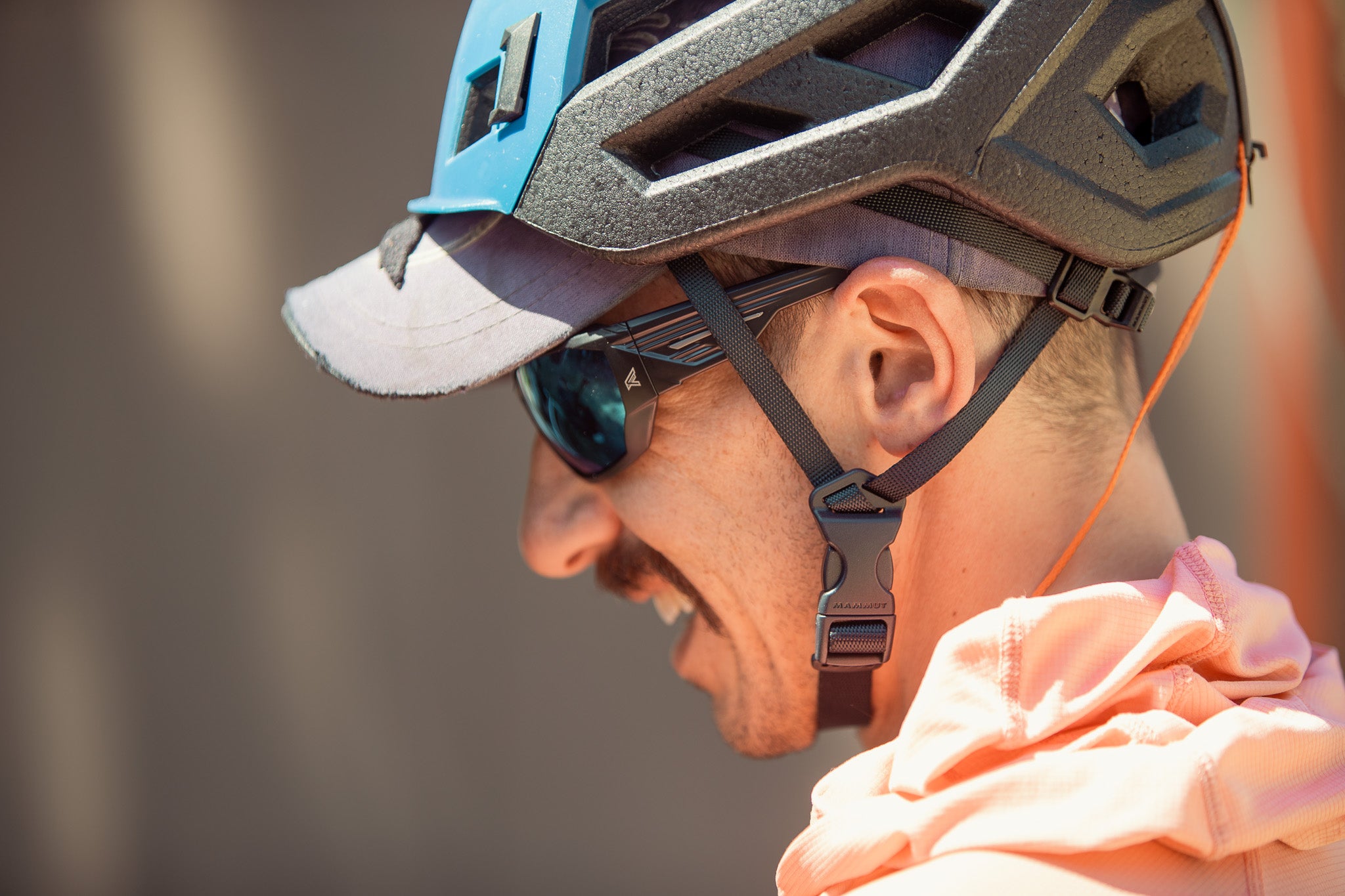 Person wearing a helmet and safety sunglasses with a blurred background