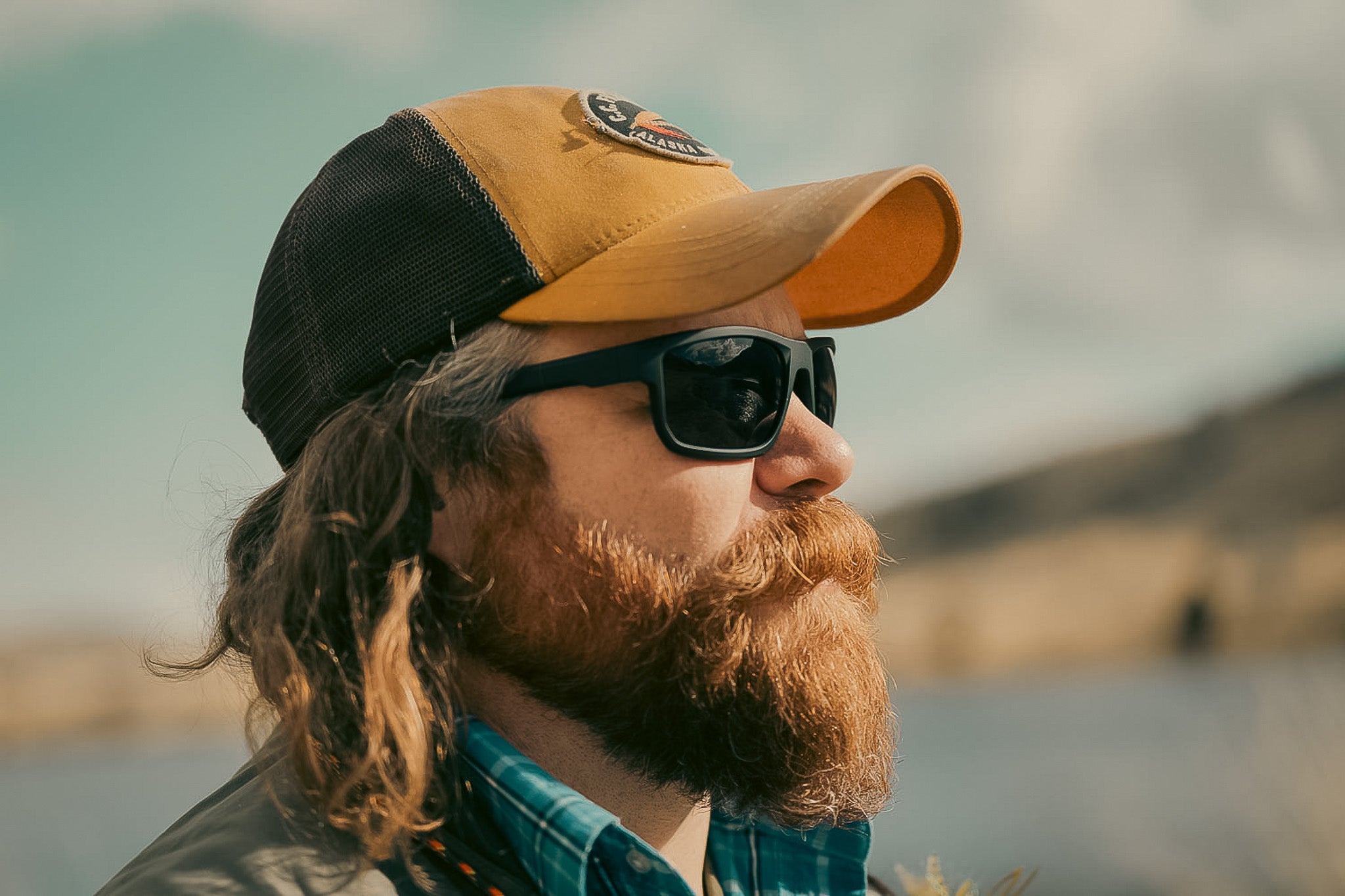 man with cap wearing safety sunglasses on river