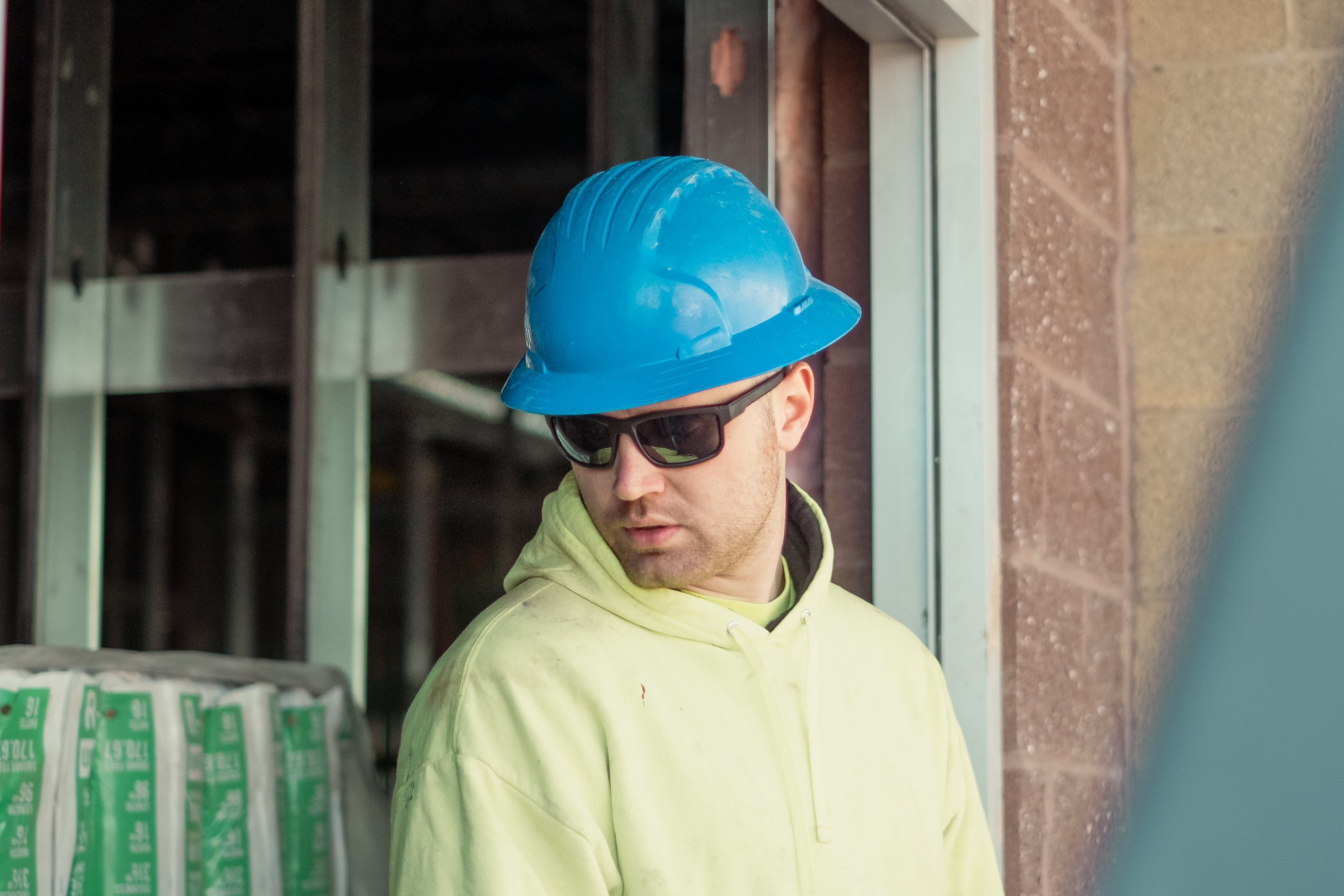 man wearing blue hard hat and safety sunglasses