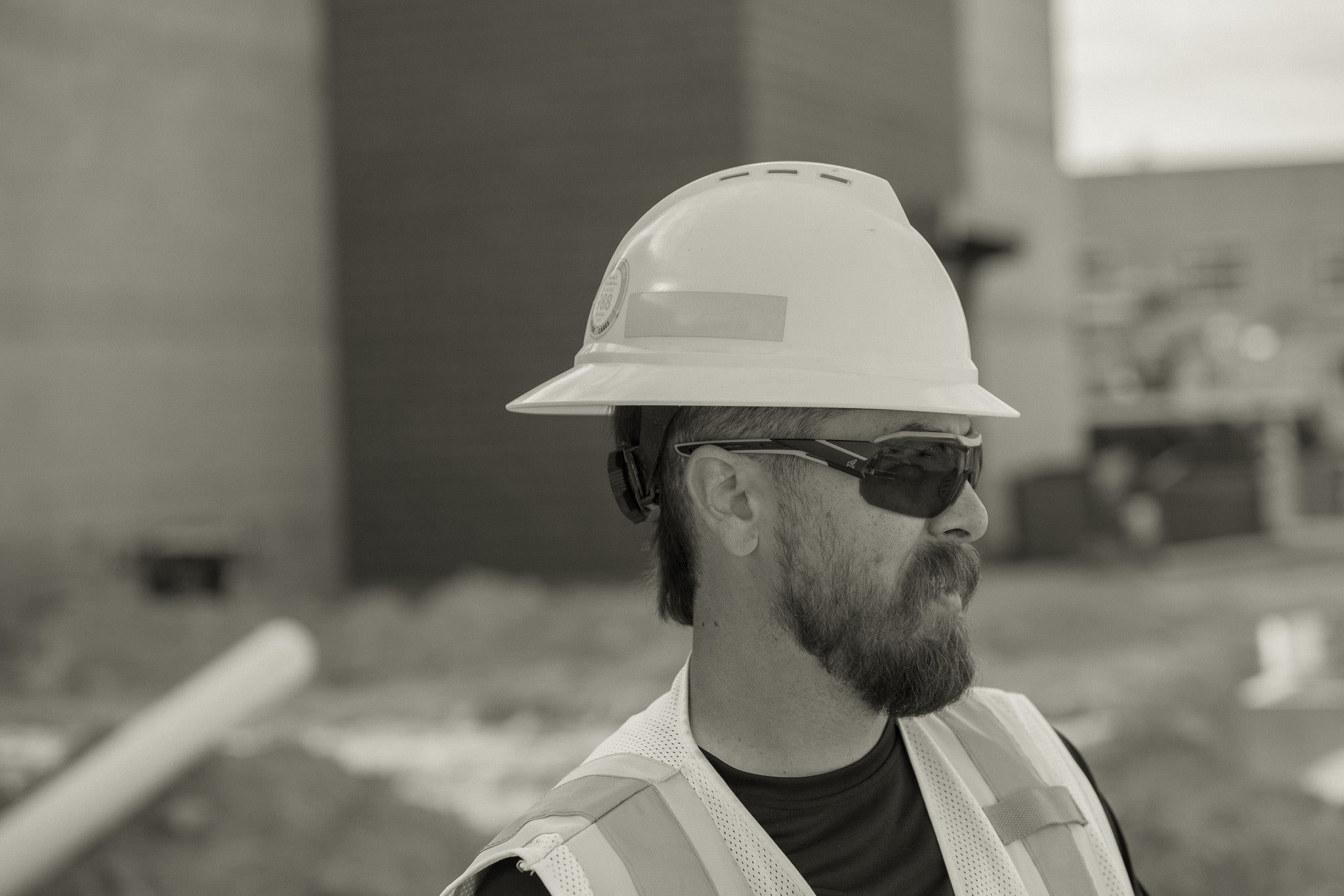 Person wearing a hard hat and safety glasses on a construction site