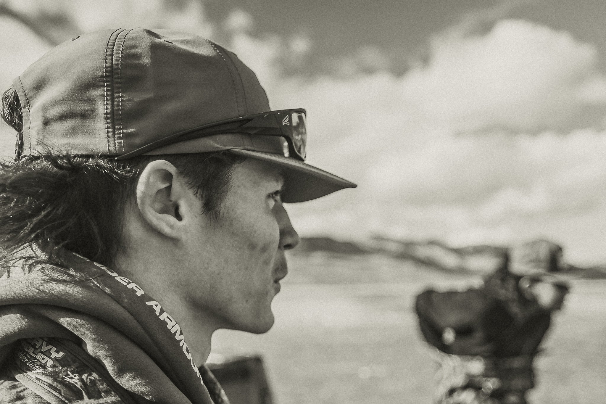 man with hat and sunglasses overlooking mountains 