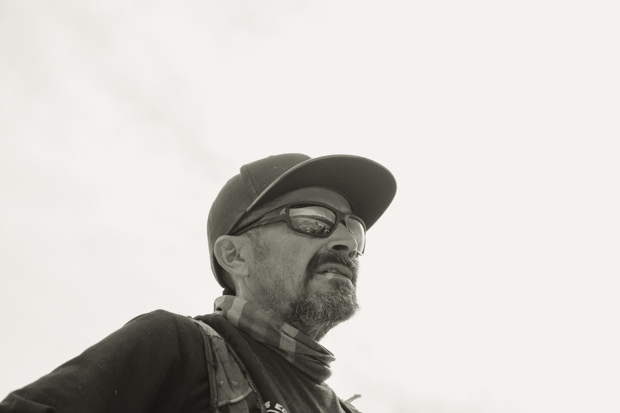 Man wearing a cap and glasses against a light background