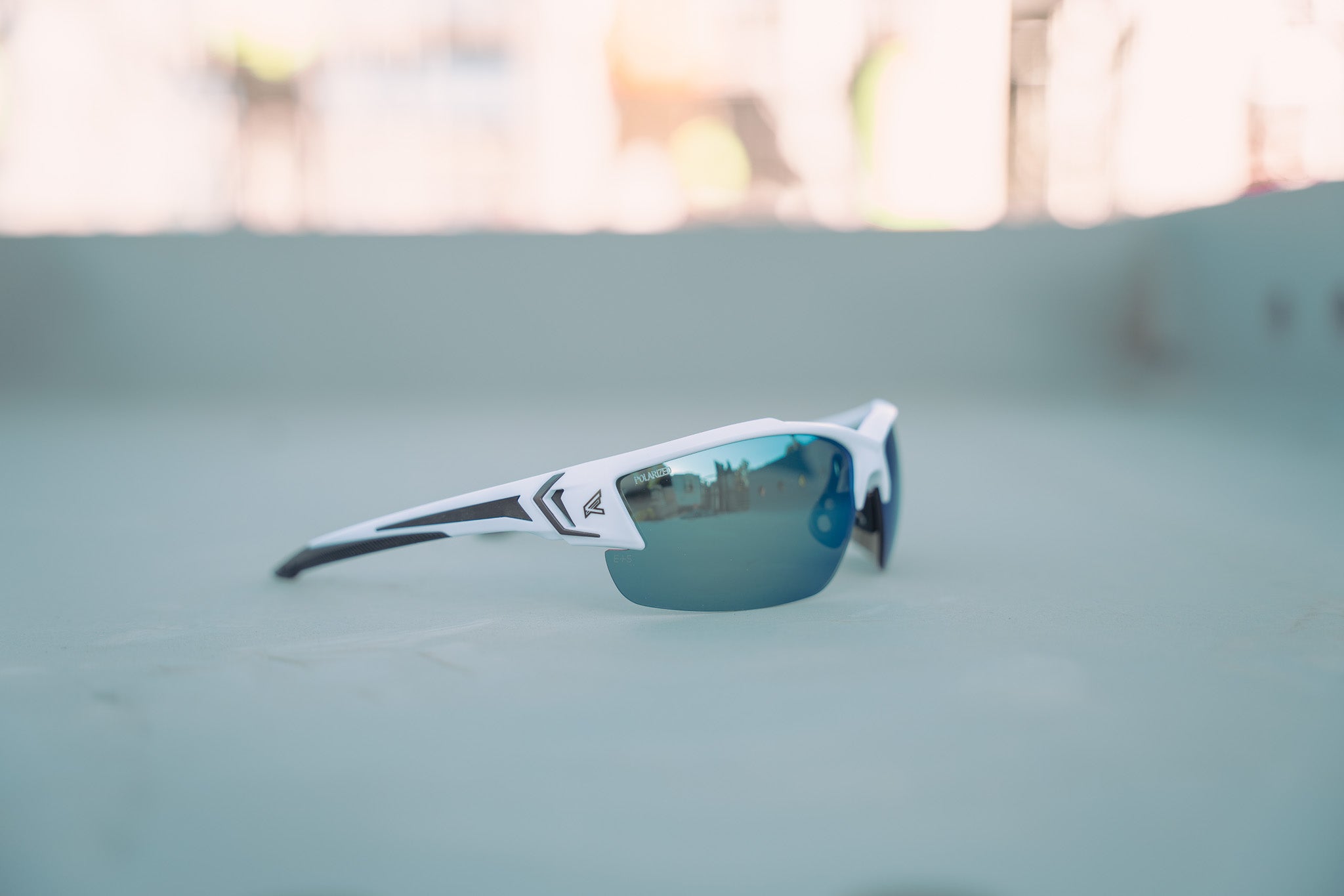 White and black safety glasses with blue lenses on a green surface