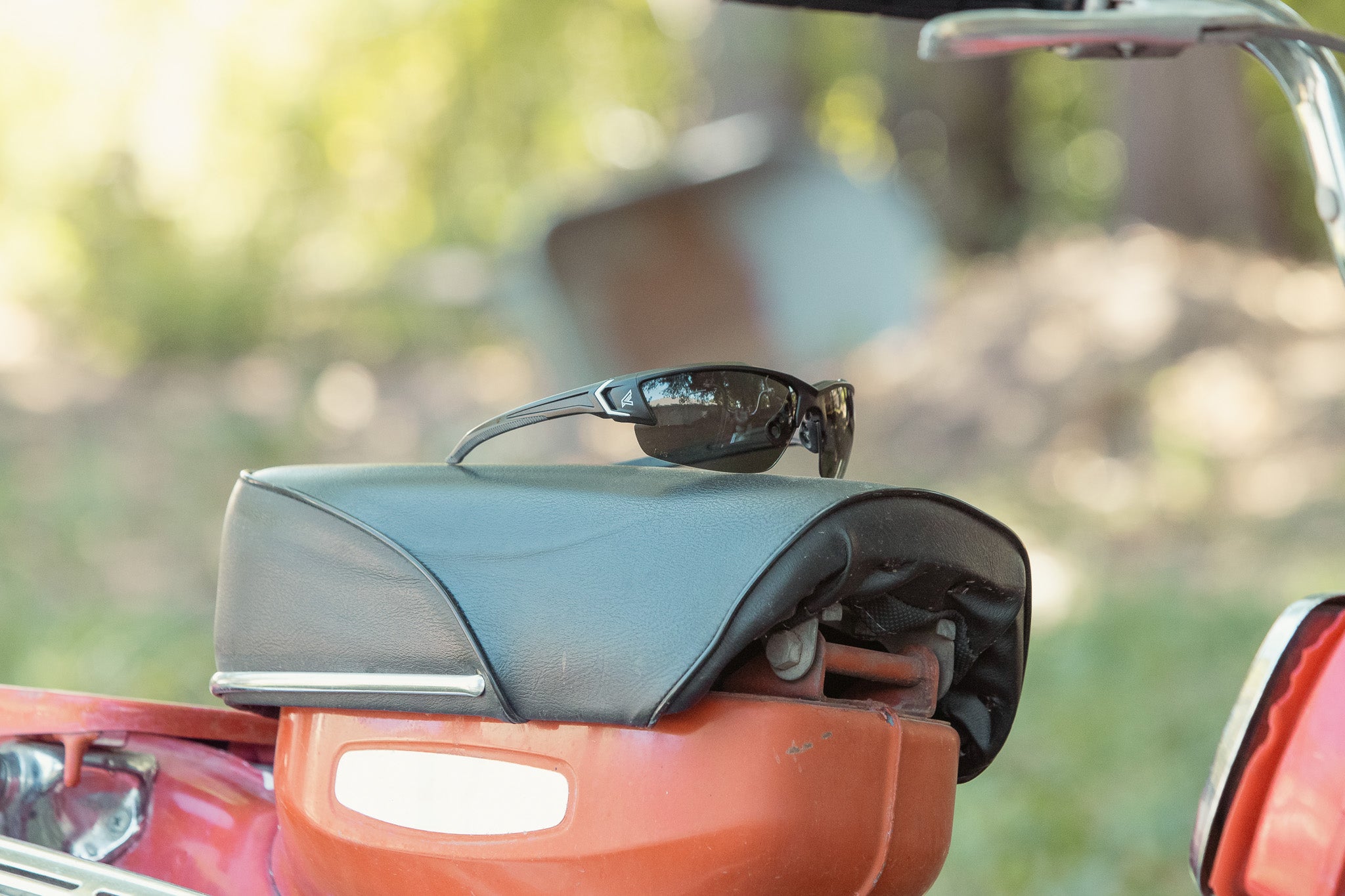 Safety sunglasses on motorcycle seat.