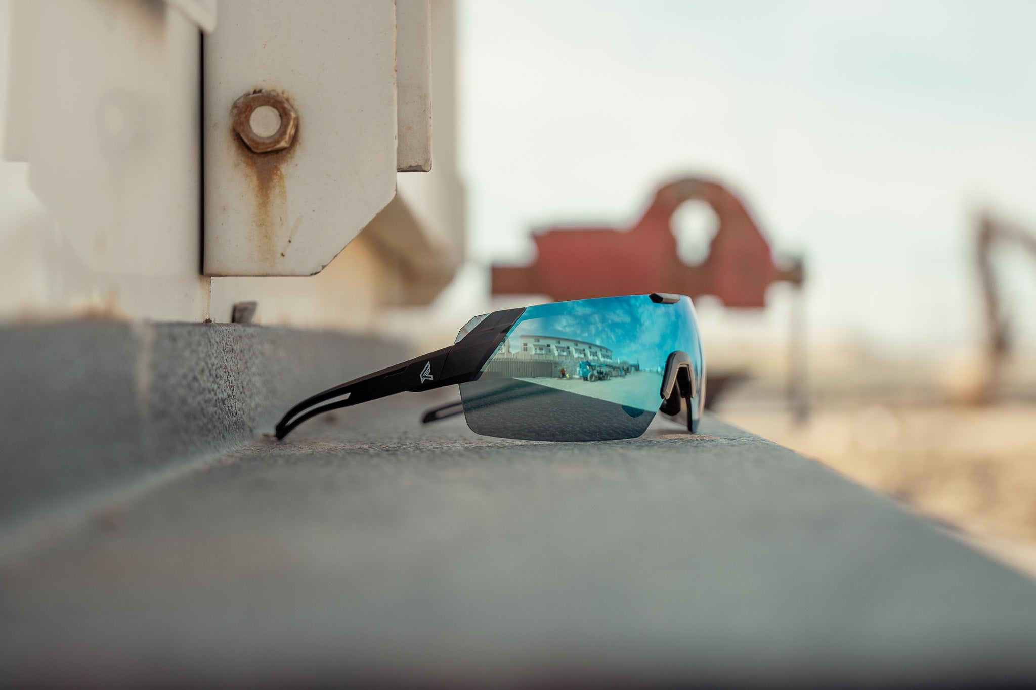 blue mirror safety glasses on a job site sitting on a piece of equipment