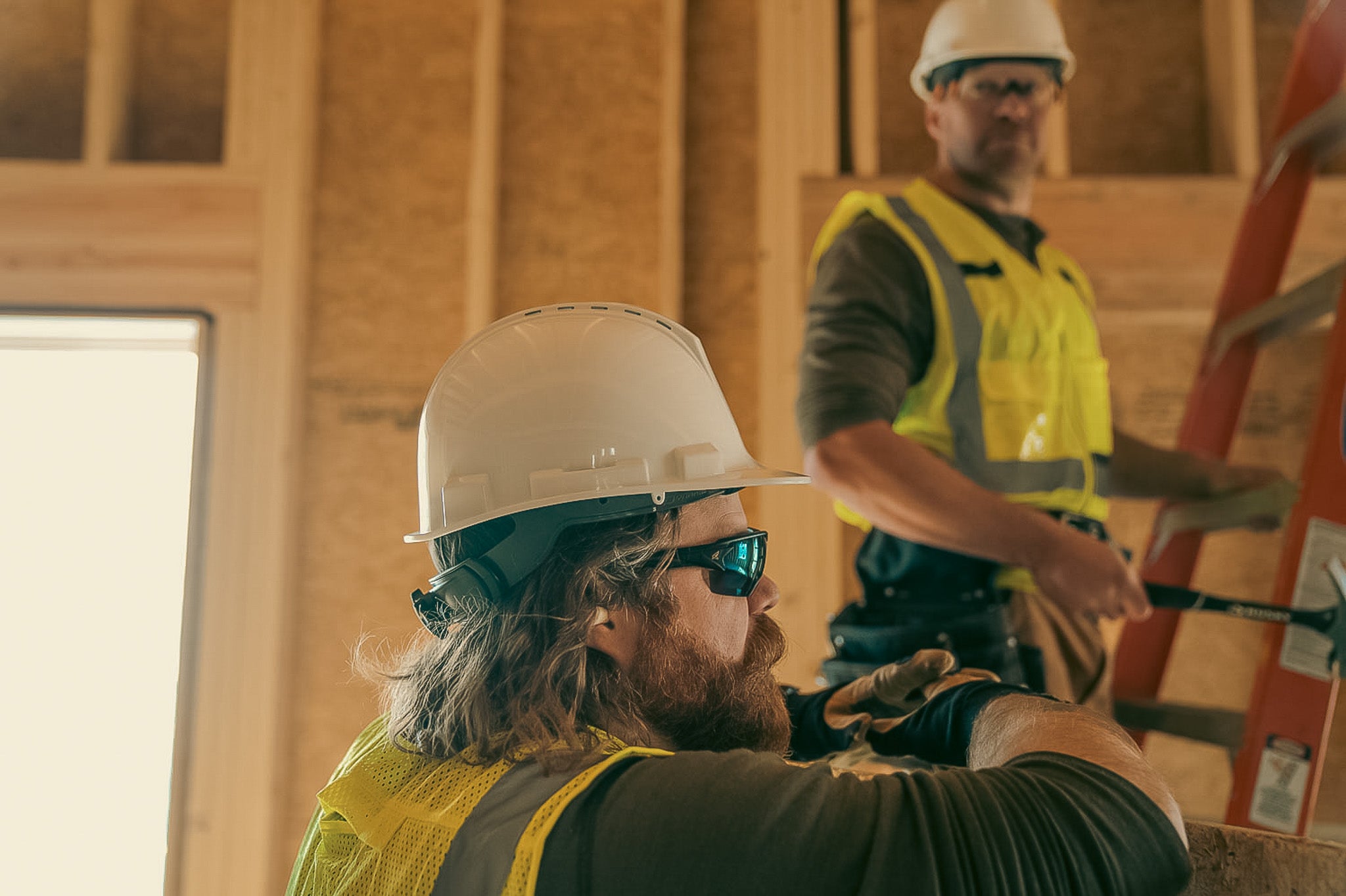 man wearing blue lens safety glasses on ladder