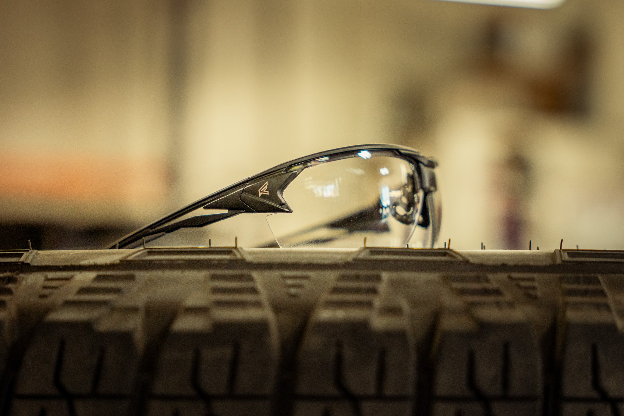 clear safety glasses sitting on tire