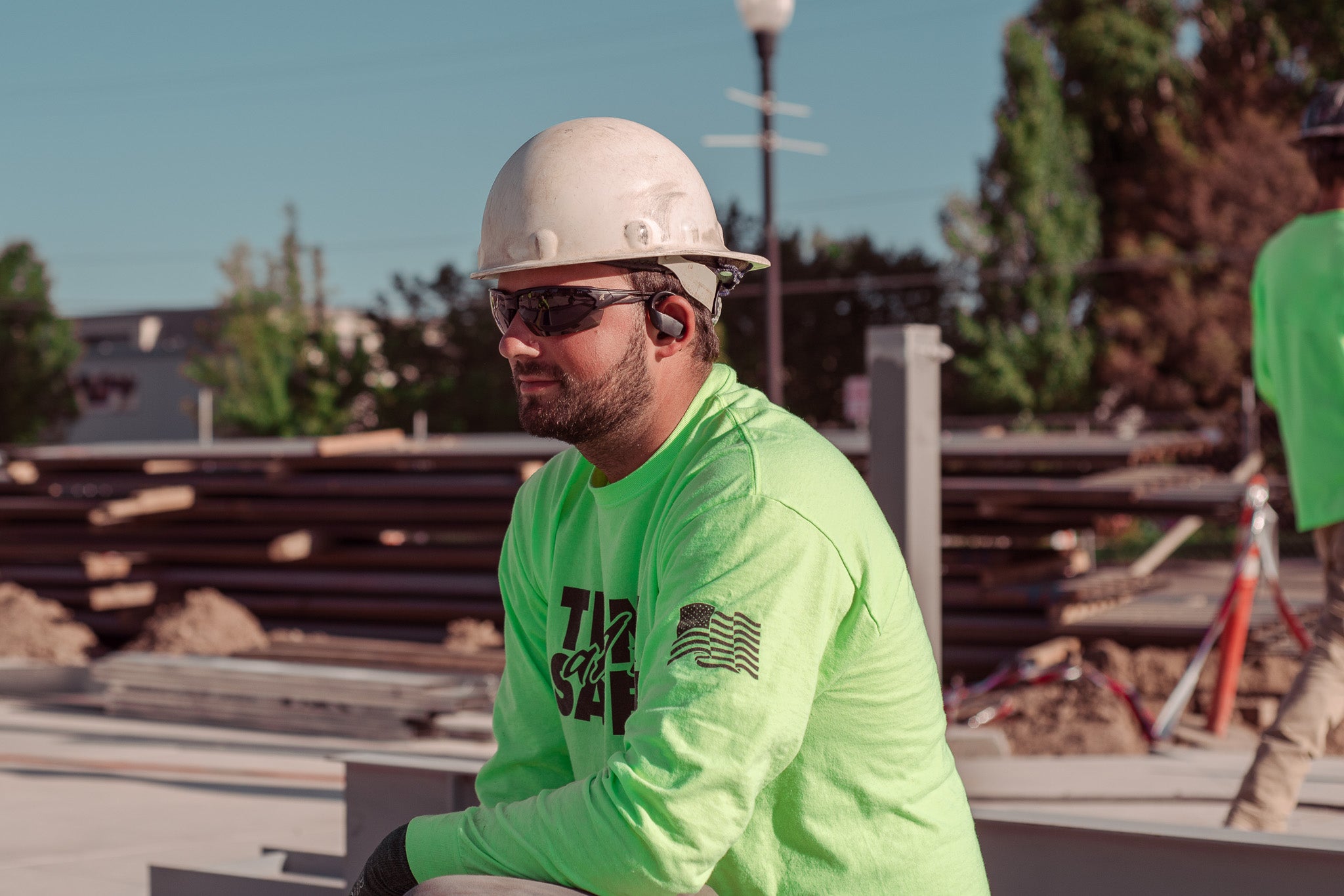 man on job wearing hard hat and safety glasses kneeling
