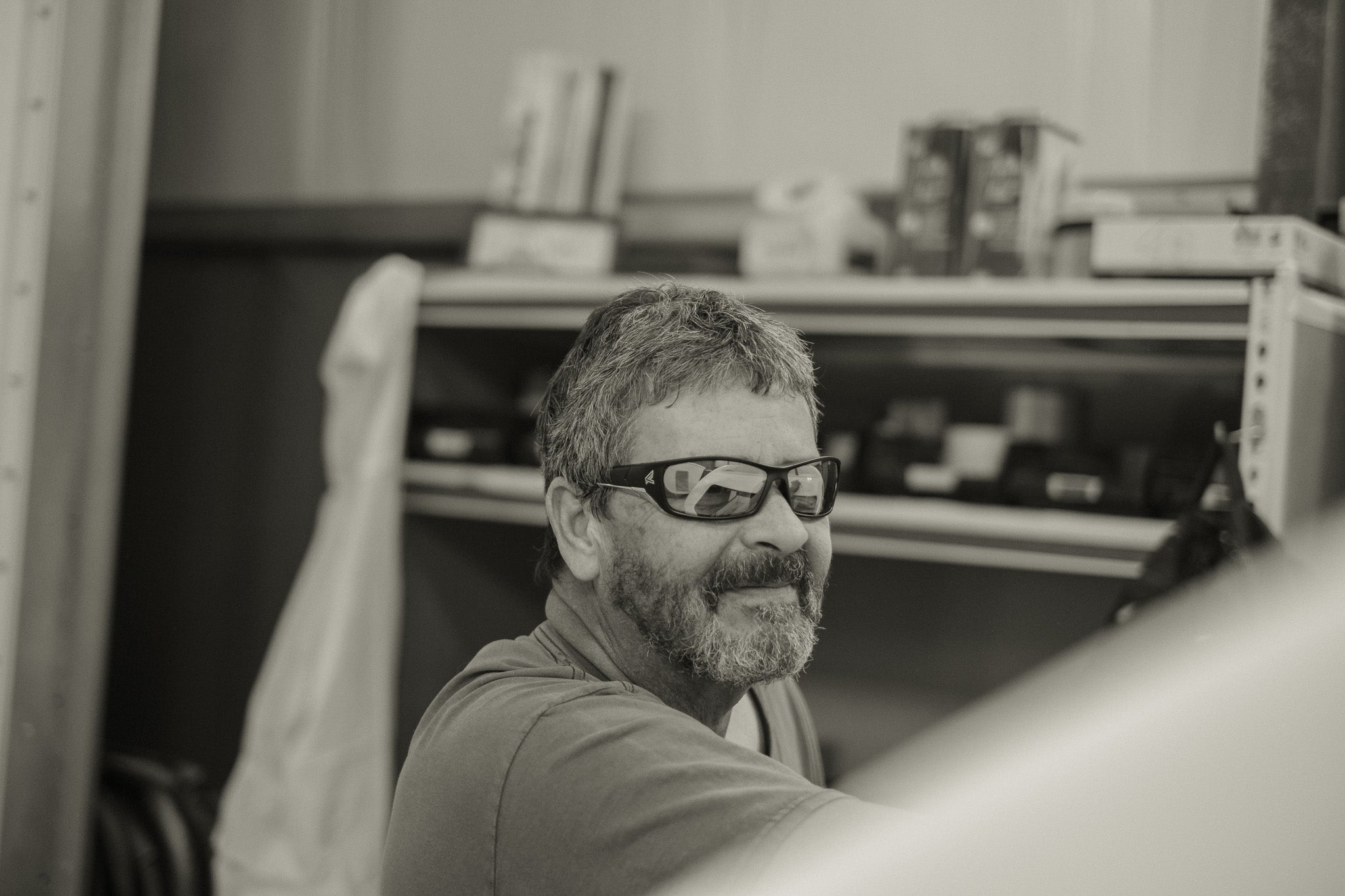 Man with safety glasses and a beard working in a factory