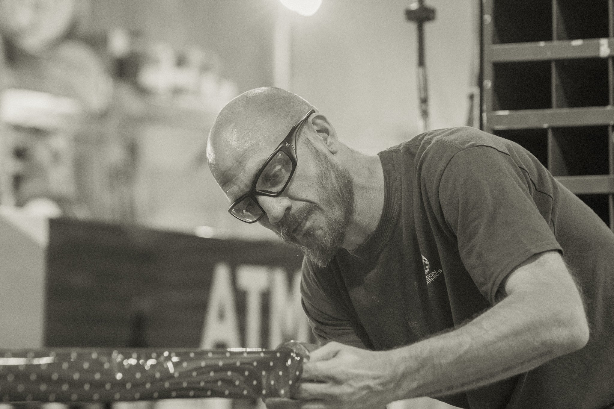 man in factory working on a bench wearing safety glasses