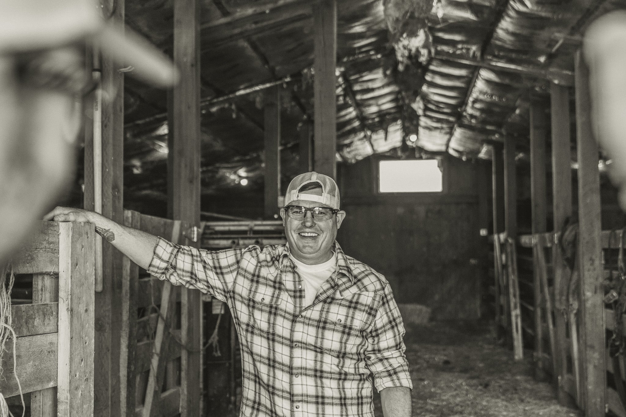 man in barn with safety glasses and baseball cap