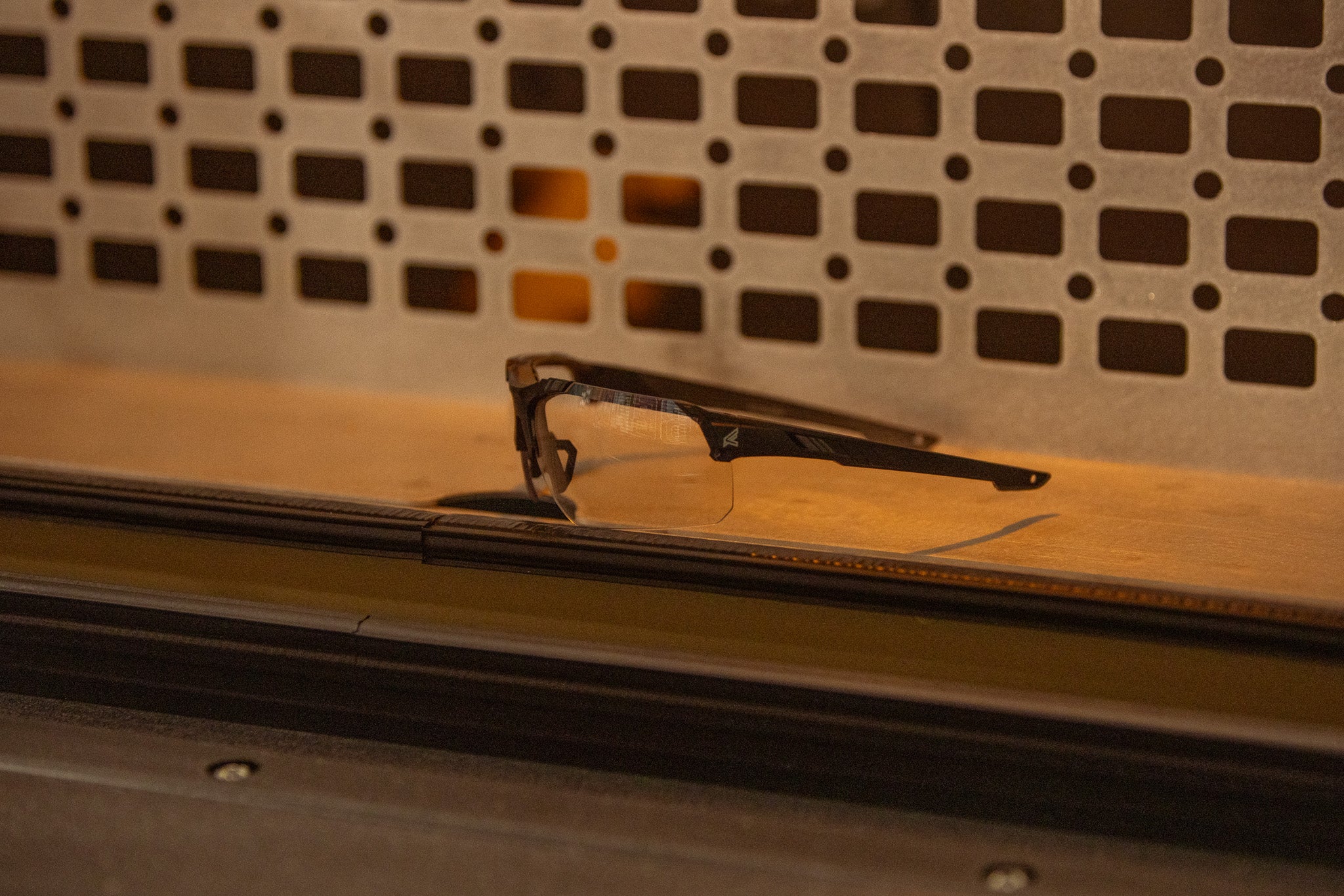 clear safety glasses sitting on a wood surface with dramatic lighting