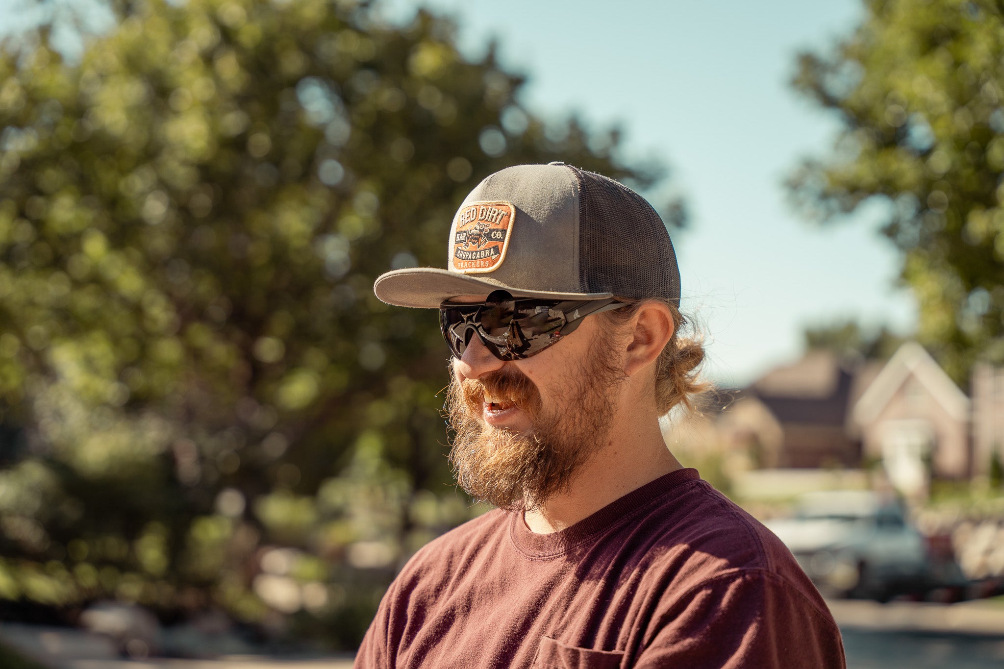 man wearing a baseball cap and safety sunglasses outdoors